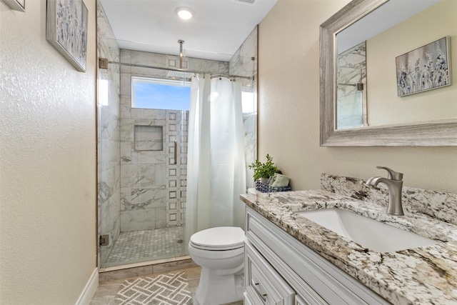 bathroom with vanity, a shower with door, and toilet