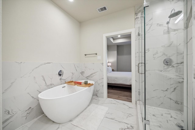 bathroom featuring independent shower and bath and tile walls