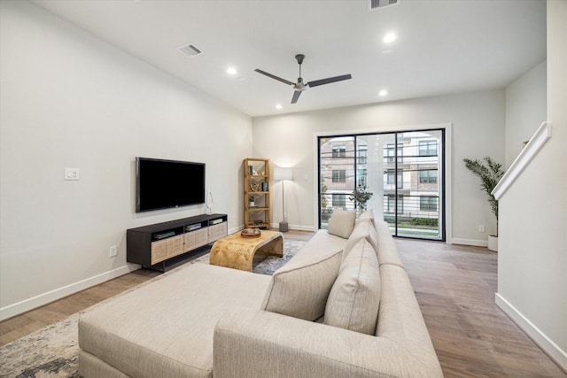 living room featuring hardwood / wood-style floors and ceiling fan