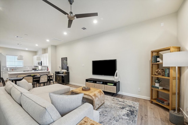 living room featuring ceiling fan and light wood-type flooring