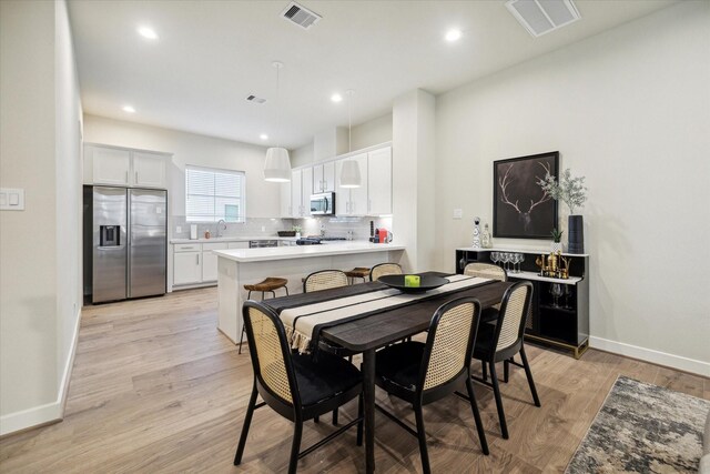 dining room with sink and light hardwood / wood-style floors