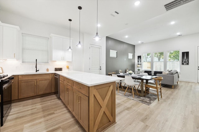 kitchen with dishwasher, sink, white cabinets, hanging light fixtures, and stove