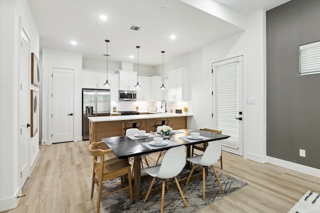 dining area with sink and light hardwood / wood-style flooring