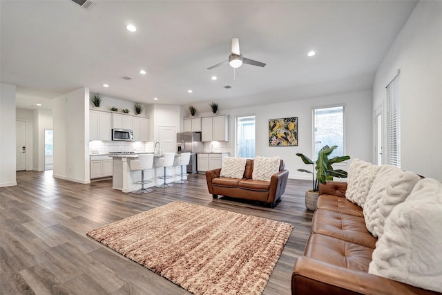 living room featuring dark wood-type flooring and ceiling fan