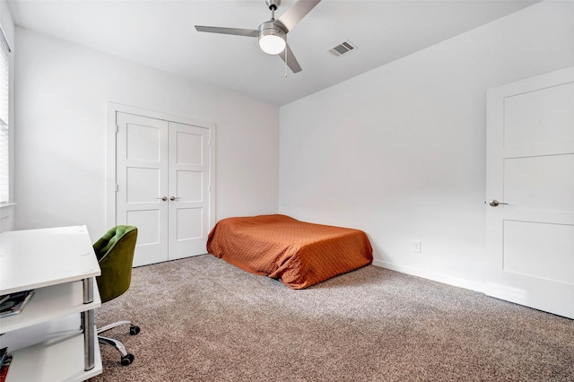 carpeted bedroom with ceiling fan and a closet