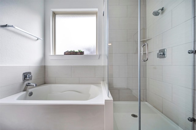 bathroom featuring separate shower and tub