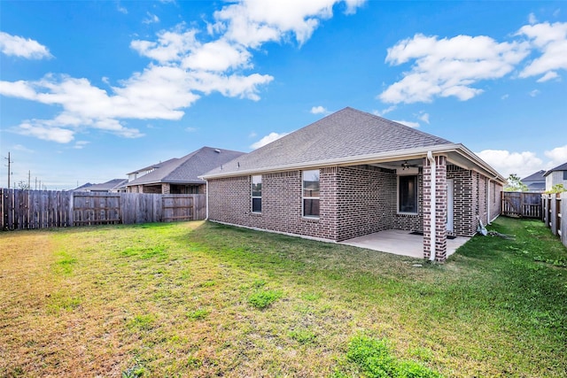 rear view of house featuring a yard and a patio area