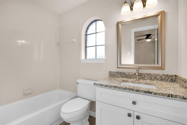 full bathroom with tiled shower / bath combo, vanity, ceiling fan, and toilet