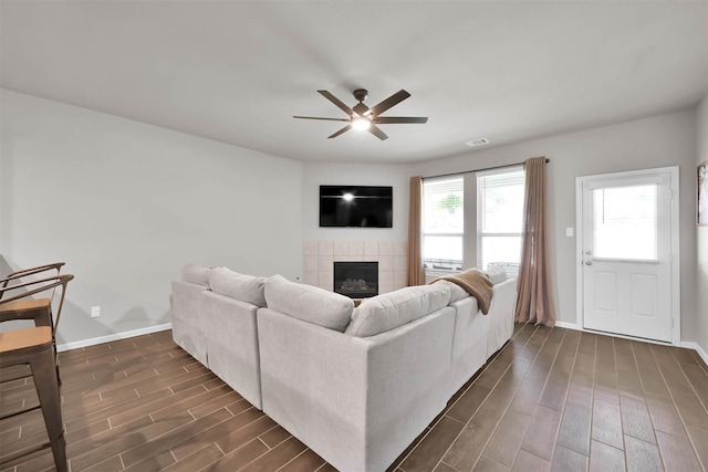 living room with ceiling fan and a fireplace