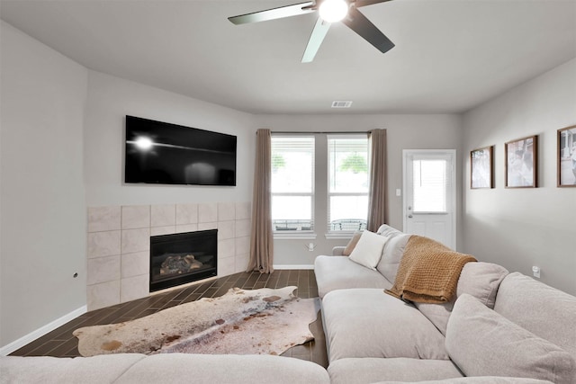 living room with ceiling fan, a fireplace, and a healthy amount of sunlight