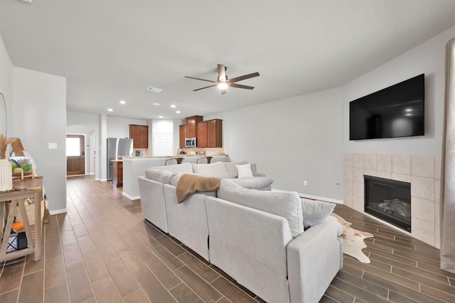 living room featuring a fireplace and ceiling fan