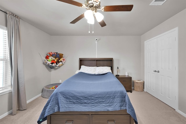 carpeted bedroom featuring ceiling fan and a closet