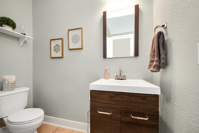 bathroom with vanity, wood-type flooring, and toilet