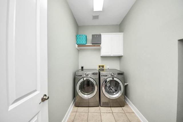 washroom featuring cabinets, washer and dryer, and light tile patterned floors