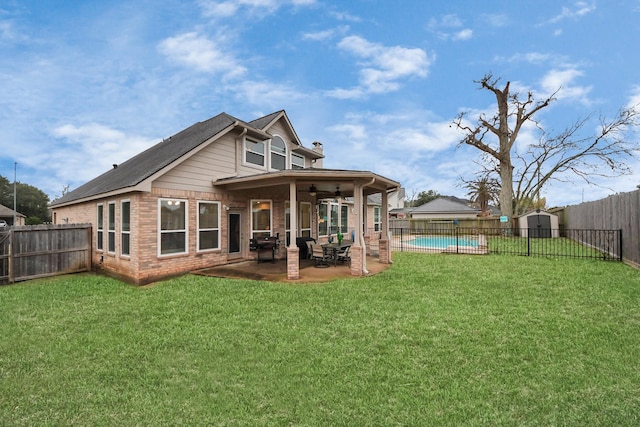 back of property featuring a fenced in pool, a yard, ceiling fan, and a patio area