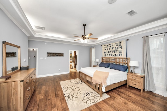 bedroom featuring crown molding, ceiling fan, dark hardwood / wood-style flooring, and a raised ceiling