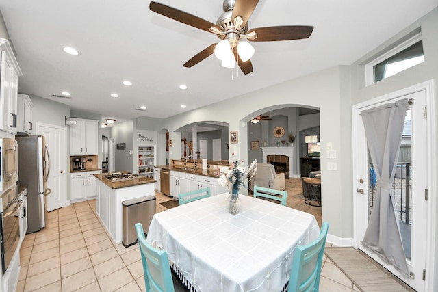 dining room featuring sink, light tile patterned floors, and ceiling fan