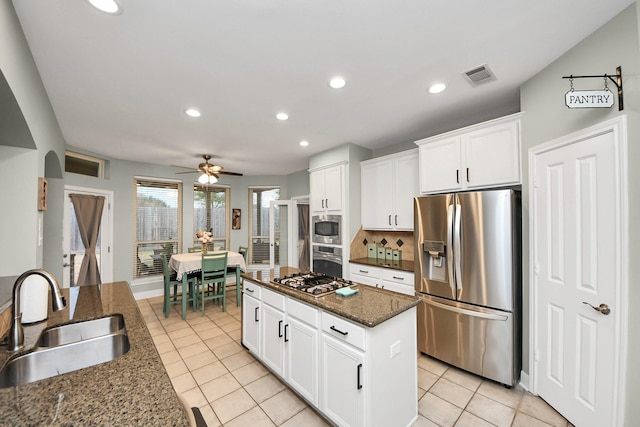 kitchen with sink, dark stone counters, white cabinets, and appliances with stainless steel finishes