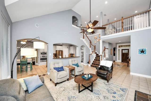 living room featuring light tile patterned flooring, high vaulted ceiling, and ceiling fan