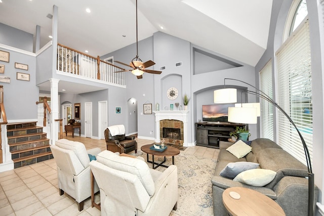 living room featuring ornate columns, ceiling fan, high vaulted ceiling, and a fireplace