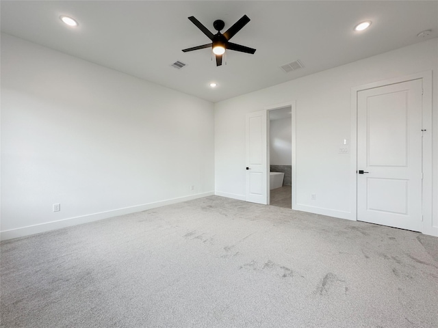 interior space featuring ceiling fan, ensuite bath, and carpet floors