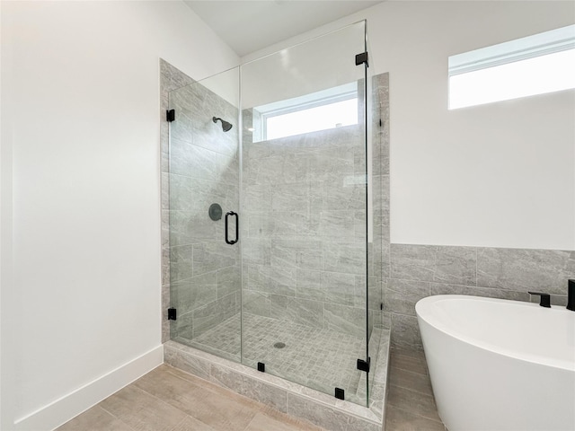 bathroom with independent shower and bath, a wealth of natural light, and tile patterned floors