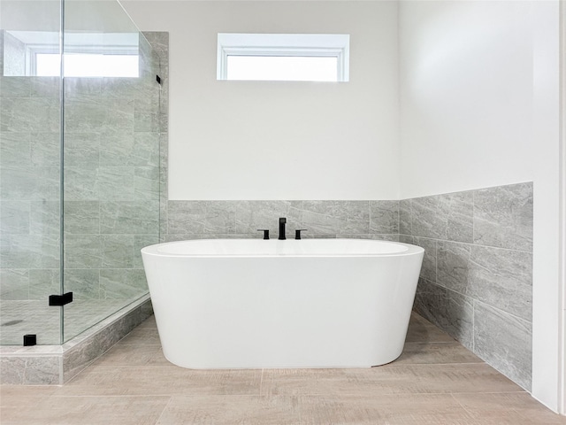 bathroom with independent shower and bath and tile walls