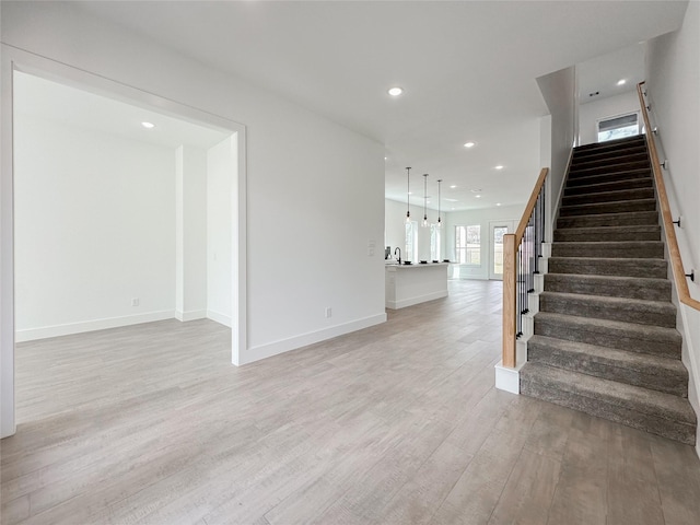 stairs featuring sink and hardwood / wood-style floors