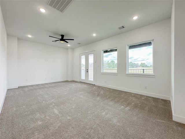 spare room with french doors, ceiling fan, and carpet