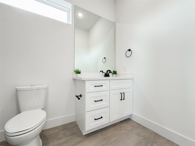 bathroom featuring vanity, wood-type flooring, and toilet