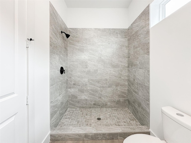 bathroom with tiled shower and toilet