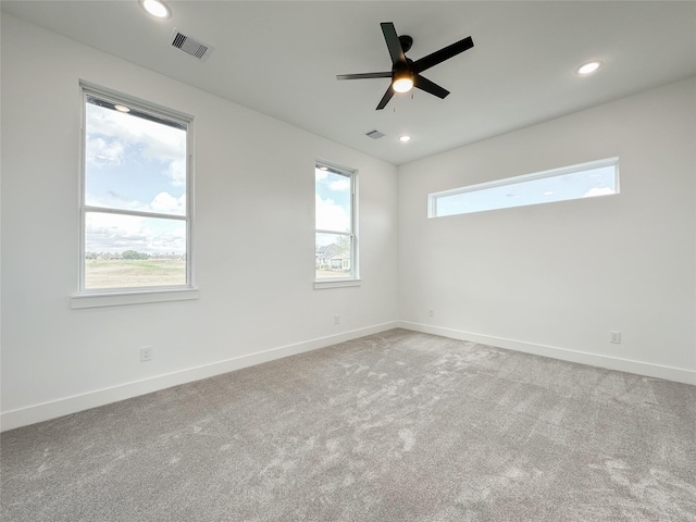 spare room featuring light carpet and ceiling fan