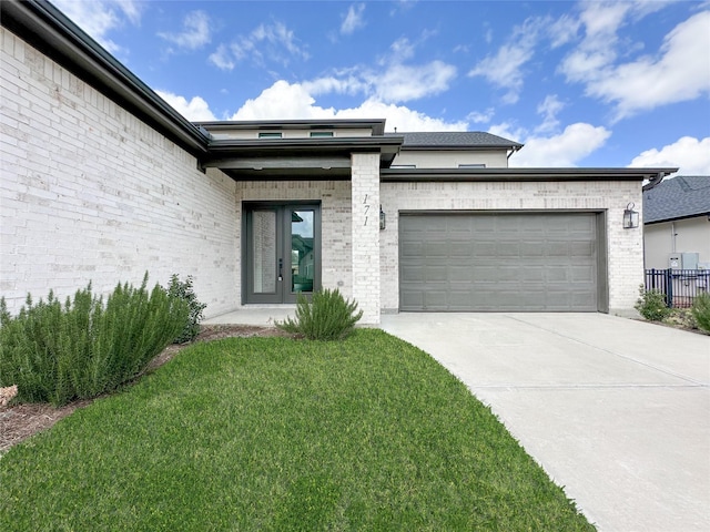 view of front of property with a garage and a front lawn