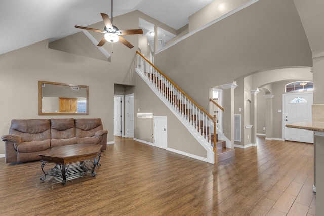 living room with ornate columns, wood-type flooring, lofted ceiling, and ceiling fan