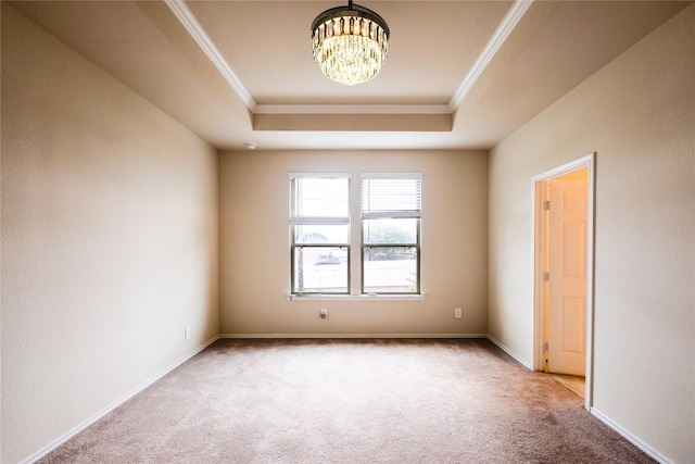 carpeted spare room with a raised ceiling, crown molding, and an inviting chandelier