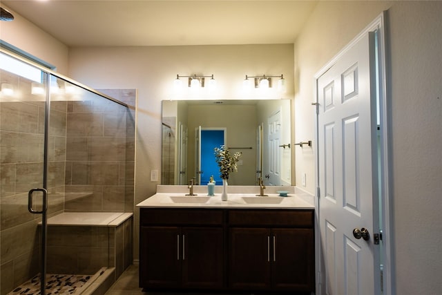 bathroom featuring a shower with door and vanity