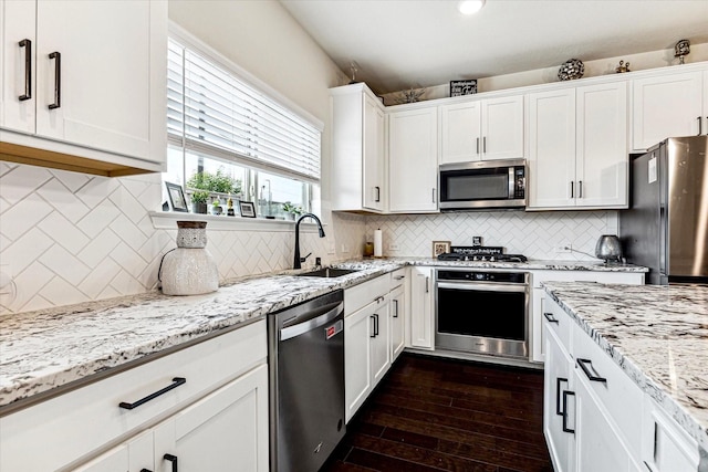 kitchen with dark wood-type flooring, sink, white cabinetry, light stone counters, and stainless steel appliances