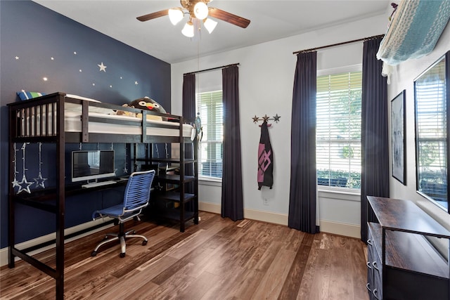 bedroom with ceiling fan, wood finished floors, and baseboards