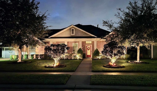 view of front facade featuring brick siding and a front lawn