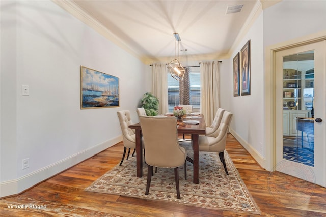 dining room with a notable chandelier, visible vents, ornamental molding, wood finished floors, and baseboards