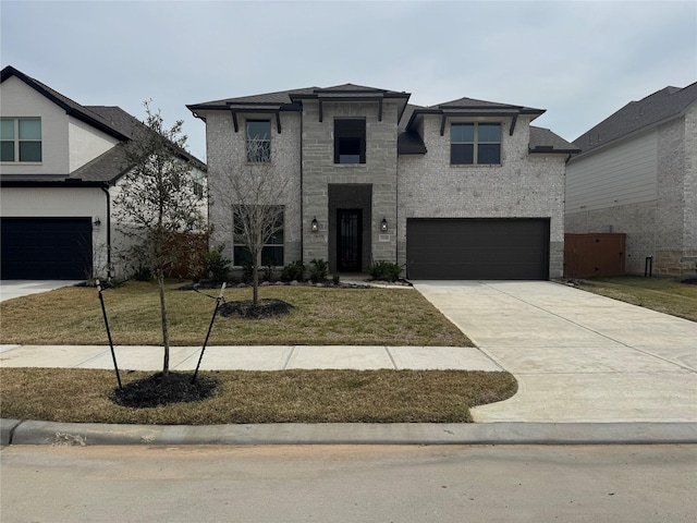 view of front of property featuring a garage, concrete driveway, and a front lawn