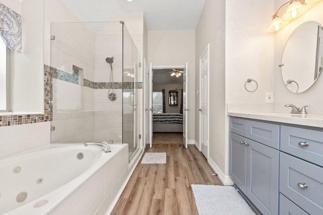 bathroom with vanity, hardwood / wood-style flooring, independent shower and bath, and ceiling fan