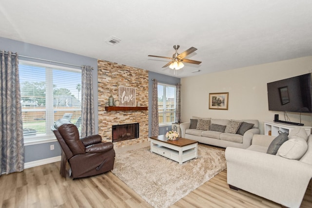 living room featuring hardwood / wood-style floors, a fireplace, and ceiling fan