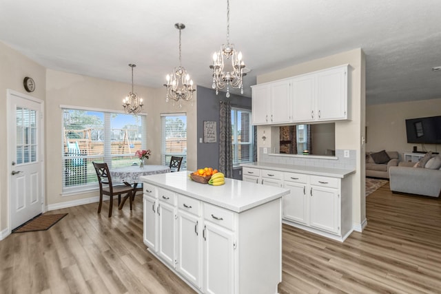 kitchen with pendant lighting, white cabinets, and light wood-type flooring