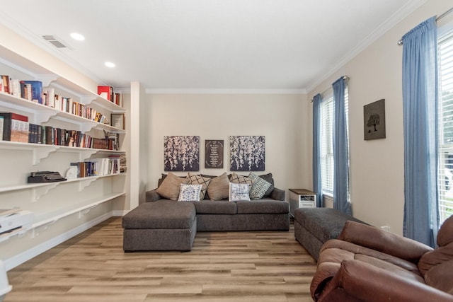 living area with ornamental molding and light hardwood / wood-style flooring