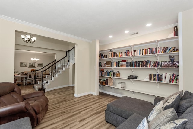 living room featuring an inviting chandelier, hardwood / wood-style flooring, and ornamental molding