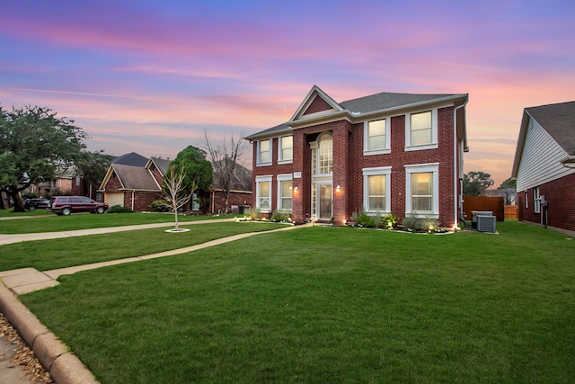 view of front facade with central AC unit and a lawn