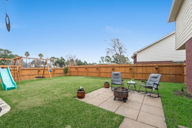 view of yard featuring a playground, a patio area, and a fire pit