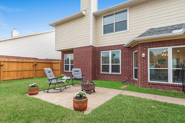 back of house featuring an outdoor fire pit, a patio area, and a lawn