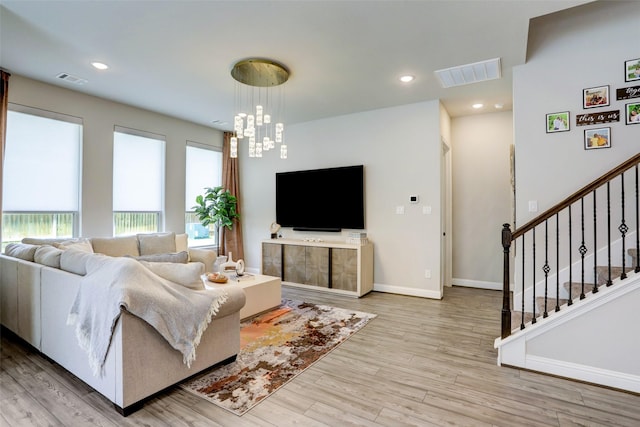 living room featuring a notable chandelier and light hardwood / wood-style flooring